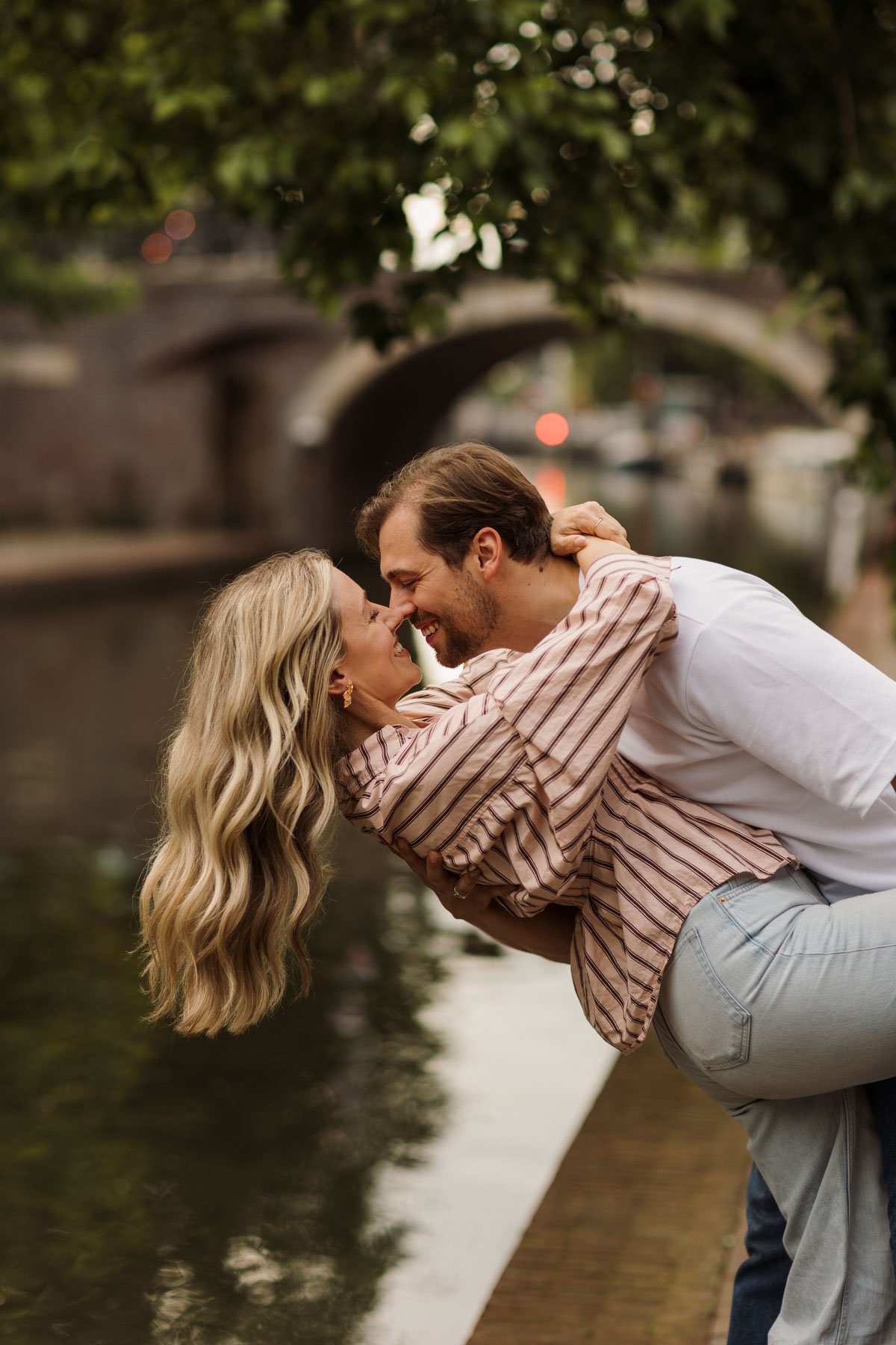 Couple laughing beside a canal in Utrecht during a romantic couples photography session