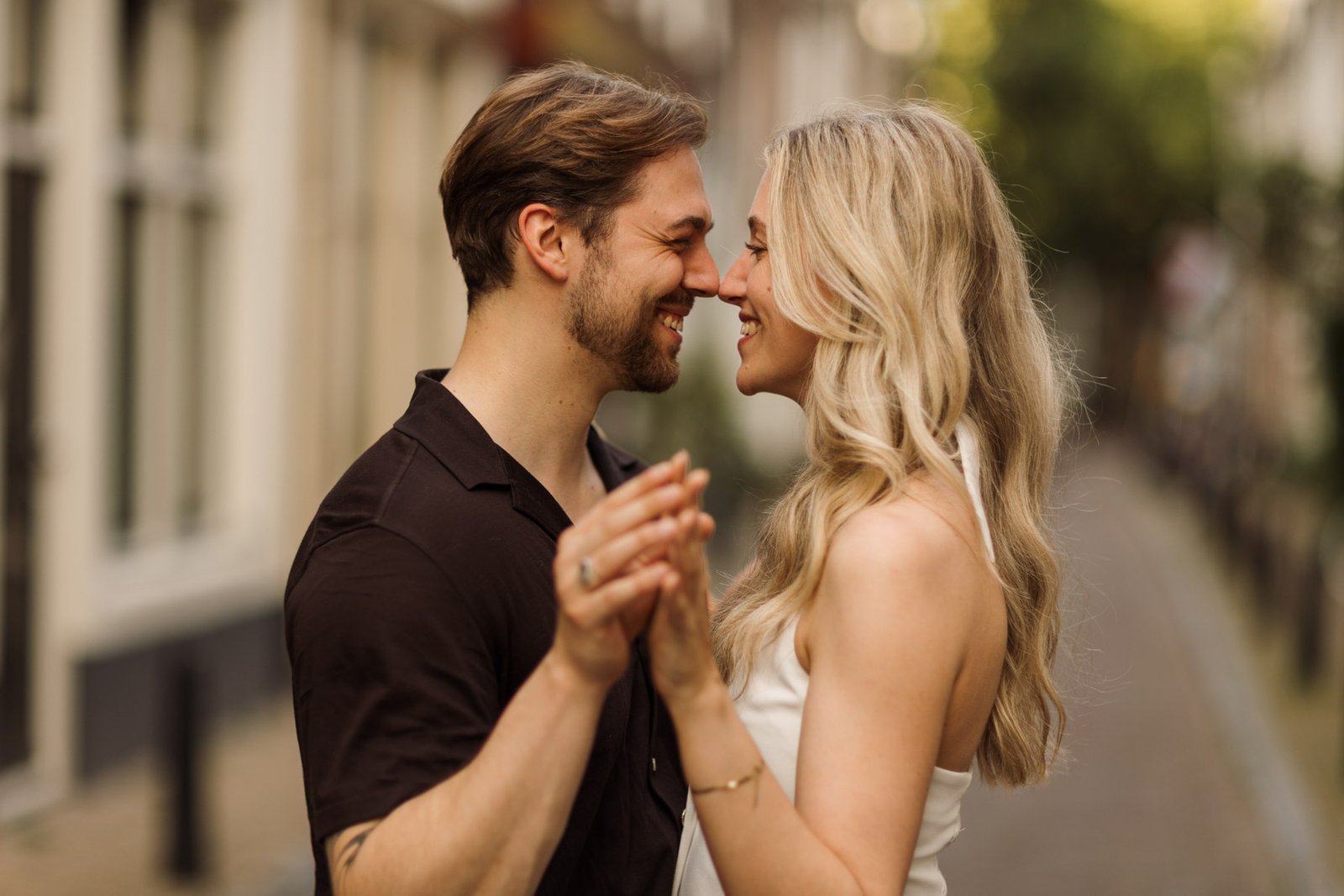 Couple smiling and holding hands during a romantic couples photography session in Utrecht